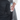 Person placing a water bottle in the side pocket of a Sherpani Camden Raven Black Classic Backpack.