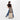 Woman holding a Sherpani Camden Dune Ultimate Backpack on top of Sherpani Meridian Chai luggage on white background.  #color_dune-tan