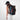 Woman wearing a Sherpani Juno Chromatic Black Duffel Backpack on her back against white backdrop. #color_chromatic-black