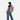Woman wearing a Sherpani Juno Dune Duffel Backpack on her back against white backdrop. #color_dune-tan