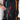 Person placing a passport into a front pocket on a Sherpani Juno Chromatic Black Duffel Backpack.