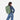 Woman wearing a Sherpani Juno Olivine Duffel Backpack on her back against white backdrop. #color_olivine-green