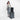 Woman holding a Sherpani Juno Raven Black Duffel Backpack on a Sherpani Meridian suitcase  against white backdrop.  #color_raven-black