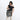 Woman holding Sherpani Soleil Houndstooth Anti-theft Multi-Wear Travel Bag by handheld straps on white backdrop. #color_houndstooth-print