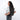 Woman wearing a Sherpani Tempest Carbon Black Convertible Tote on her back against white background. #color_carbon-black
