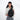 A woman wearing a Sherpani Wayfarer Raven Black Convertible Sling on her front against white background.  #color_raven-black