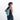 A woman wearing a Sherpani Wayfarer Surf Blue Convertible Sling on her back against white background.  #color_surf-blue