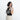 Woman holding a Sherpani Mei Passport Anti-theft Travel Trio Crossbody by the short strap over her shoulder against a white backdrop. #color_houndstooth-print