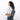 A woman wearing a Sherpani Metro Granite Anti-theft Reversible Sling on her back against a white background.  #color_granite-grey