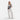 Woman wearing a Sherpani Metro Passport Anti-theft Reversible Sling on her front against white backdrop.#color_passport-print