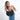 A woman holding a Sherpani Mina Chromatic Black Medium Crossbody Bag in her hands with short-strap attachment. #color_chromatic-black