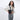 Woman wearing a Sherpani Rogue Raven Black Mini Crossbody on her shoulder against white background.  #color_raven-black