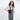 Woman wearing a Sherpani Rogue Raven Black Mini Crossbody on her shoulder against white background.  #color_raven-black
