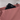 Person placing a phone inside back pocket of Sherpani Zoom Desert Pink Slim RFID Crossbody. 