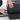 Person unzipping a Sherpani Meridian Black Checked-Luggage against white background. #color_chromatic-black