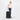 Woman holding a Sherpani Meridian Chromatic Black Checked-Luggage by the handle against white backdrop  #color_chromatic-black