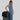 A Woman shows features of a Sherpani Jaunt Chromatic Black Garment Duffle, such as the different strap options. 