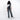 Woman wearing a Sherpani Esprit Carbon Black Anti-theft Sling on her back against white backdrop. #color_carbon-black