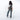 Woman wearing a Sherpani Esprit Granite  Anti-theft Sling on her back against white backdrop.  #color_granite-grey