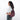 A woman wearing a Sherpani Esprit Smoky Orchid Anti-theft Sling Bag on her back against a white background. #color_smoky-orchid-pink