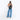 Woman wearing a Sherpani Esprit Chromatic Black Sling on her back against white backdrop. #color_chromatic-black