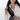 Woman wearing a Sherpani Esprit Raven Black Sling Bag with a phone inside the strap pocket.