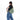 Woman wearing a Sherpani Esprit Olivine Sling on her back against white backdrop. #color_olivine-green