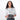 Woman holding a Sherpani Mini Co-Pilot Granite Mini Travel Organizer against white backdrop. #color_granite-grey